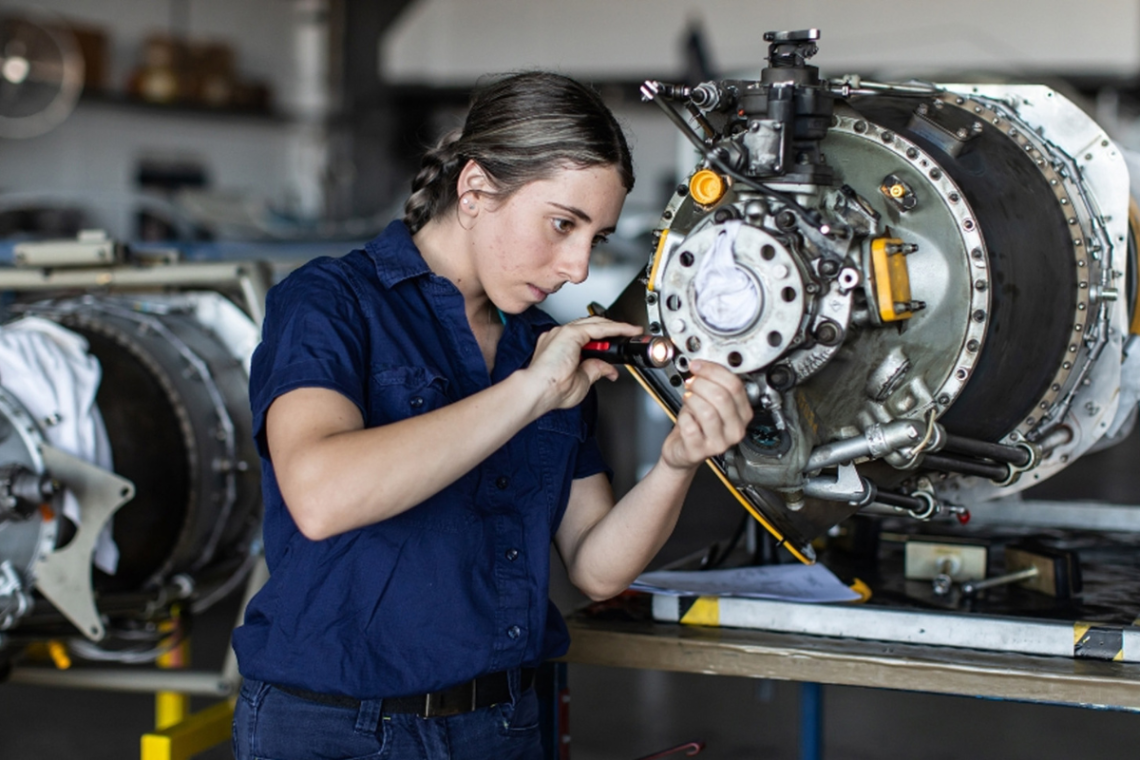Female technician working on machinery