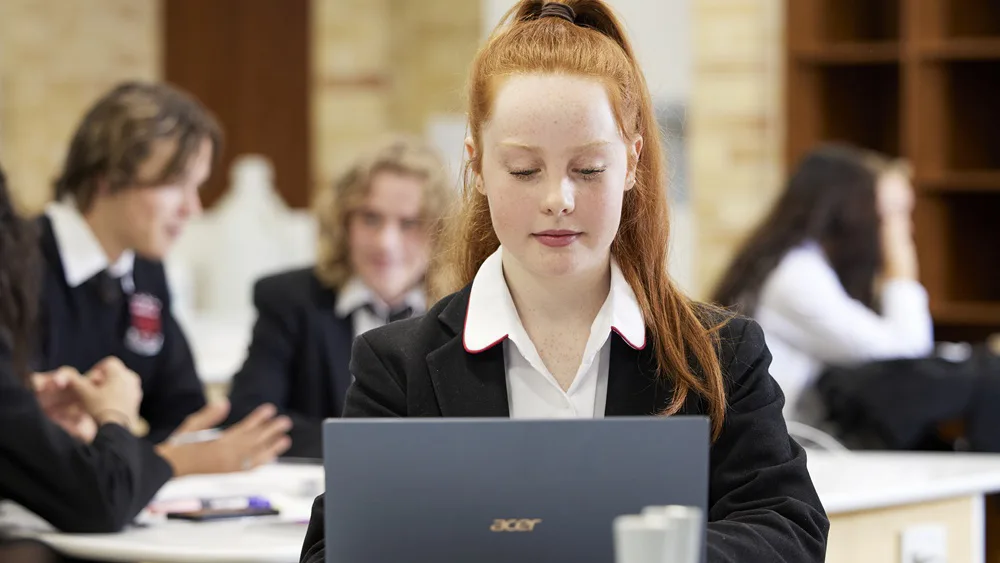 Female student working on a laptop in a classrom