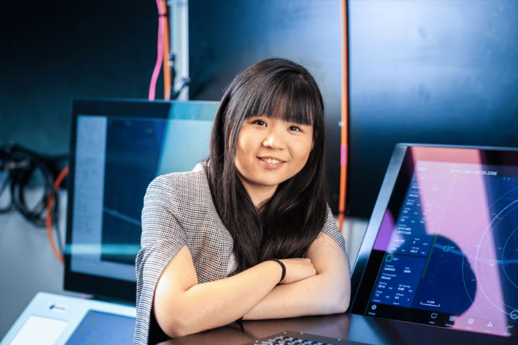 Professional young woman standing in front of a computer.