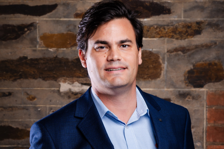 Professional male in suit standing in front of a brick wall