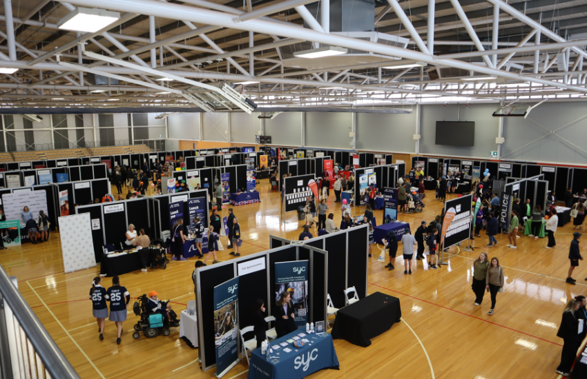 A sports hall populated with job seekers and booths